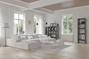 Modern loft living room interior with monochromatic white decor, a comfortable modular lounge suite and rug and accent bookcases with structural ceiling beams